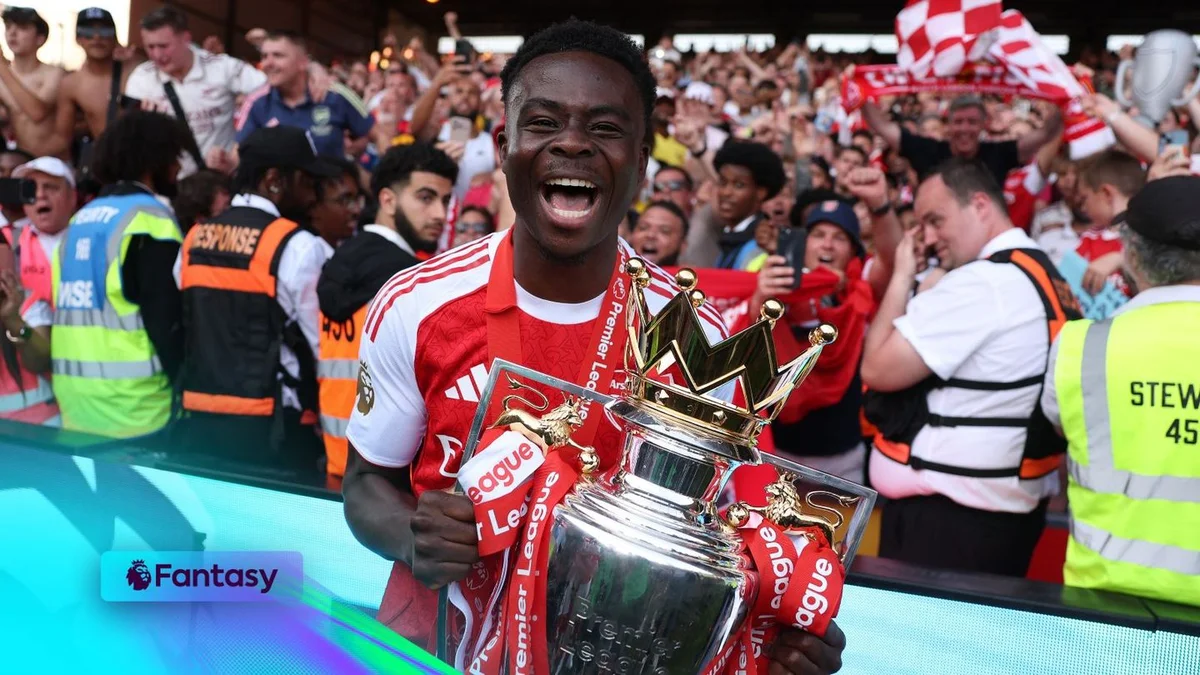 Bukayo Saka celebrating with the Premier League trophy
